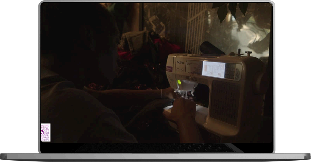 A man sewing a garment on a machine.