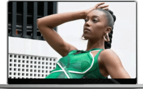 A woman poses confidently in a flowing green dress showcasing her style and elegance