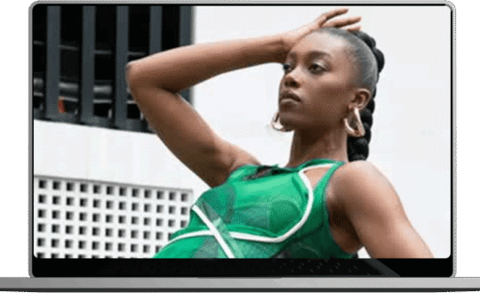 A woman poses confidently in a flowing green dress showcasing her style and elegance