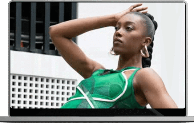 A woman poses confidently in a flowing green dress showcasing her style and elegance